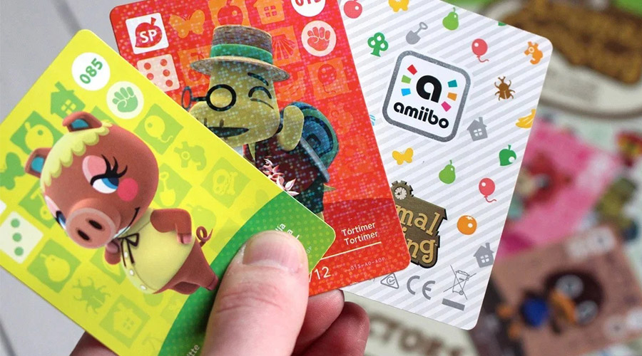 Plusieurs cartes Amiibo dans la main d'un joueur